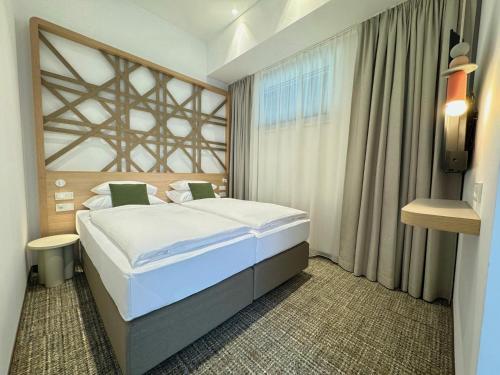 a hotel room with a bed and a window at ARCOTEL AQ Wien in Vienna