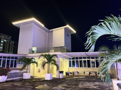 a large white building with palm trees in front of it at Sojourn Spa Hotel Melaka in Melaka
