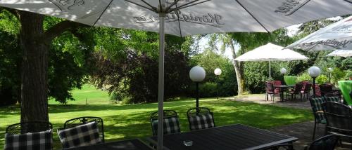 a table and chairs with umbrellas in a yard at Hotel Zur Suhle in Eschbach