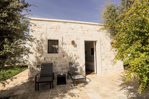 a brick building with two chairs in front of it at Ddò Relais di Puglia in Ostuni