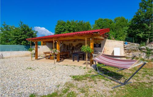 a hammock in front of a house with a roof at 3 Bedroom Beautiful Home In Ruzici in Ružići