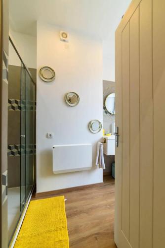 La salle de bains est pourvue de 2 lavabos et d'un tapis jaune. dans l'établissement Maison conviviale à Douai avec jardin - 90 m², à Douai