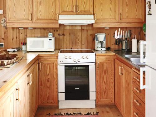 a kitchen with wooden cabinets and a white oven at 4 star holiday home in KALV in Kalv