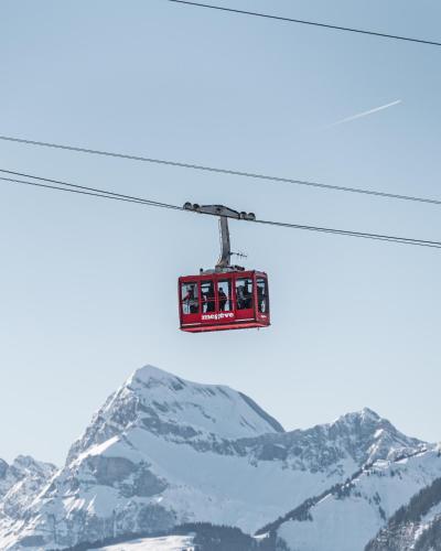 a ski lift with people on it flying over a mountain at Coeur de Megève in Megève