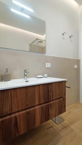 a bathroom with a sink and a mirror at Lacugnano Apartment La tua casa in umbria in Perugia