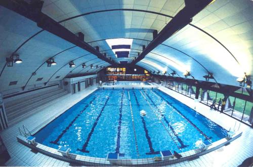 une grande piscine intérieure d'eau bleue dans l'établissement Appartement Le Bel Air - balcon et parking gratuit, à Annecy