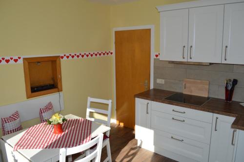 a kitchen with a table and a kitchen with white cabinets at Ferienwohnung Lenchen in Medebach