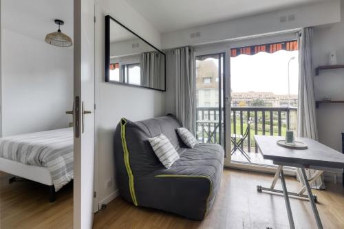 - une chambre avec un canapé, un lit et un balcon dans l'établissement L'Estran - Appt 2p proche de la mer, à Villers-sur-Mer