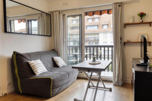 un salon avec un canapé et une table dans l'établissement L'Estran - Appt 2p proche de la mer, à Villers-sur-Mer