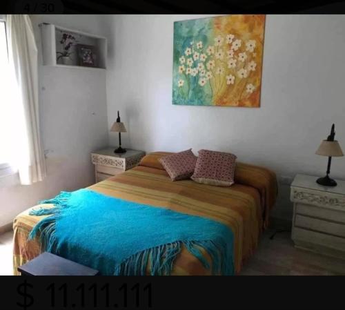 a bedroom with a bed and a painting on the wall at Casa en el Siambon in Siambón