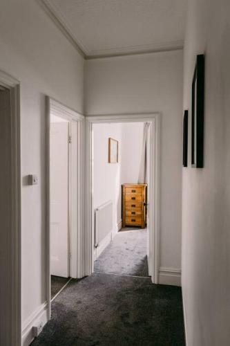an empty room with a hallway with a dresser at Dream Beach View in Weymouth