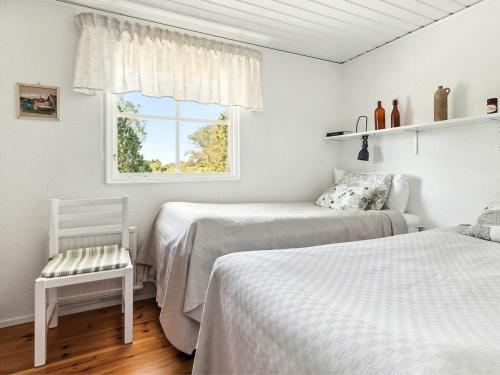 a bedroom with two beds and a window at 4 person holiday home in LÖTTORP in Löttorp