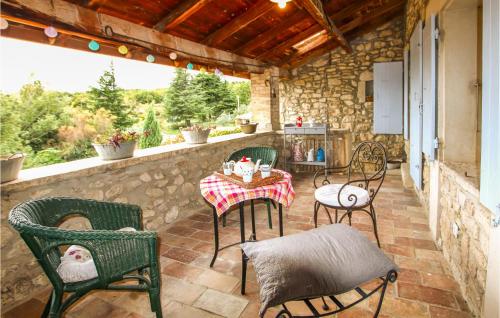 d'une terrasse avec une table et des chaises sur un mur en pierre. dans l'établissement Beautiful Home In Salles Sous Bois, à Salles-sous-Bois