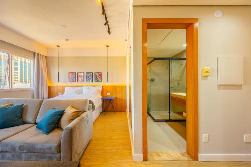 a living room with a couch and a bedroom at STD - Anora Spaces - Stadium Alphaville in Barueri