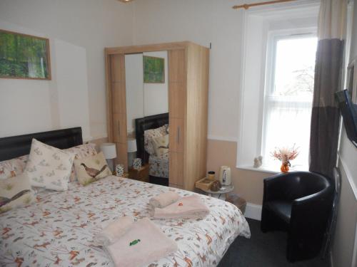 a bedroom with a bed with a chair and a window at The George B & B in Weymouth