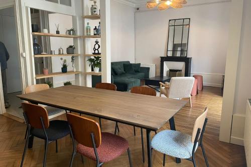 une salle à manger avec une table et des chaises en bois dans l'établissement Spacious T4 in the heart of the city center, à Nantes