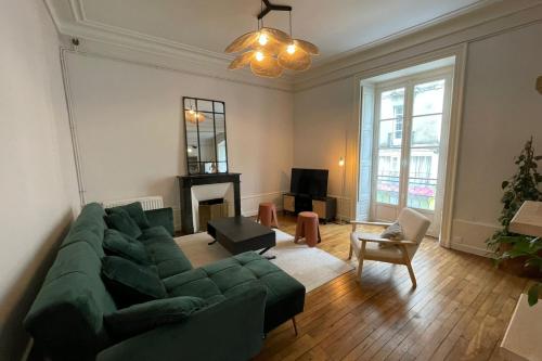 - un salon avec un canapé vert et une cheminée dans l'établissement Spacious T4 in the heart of the city center, à Nantes