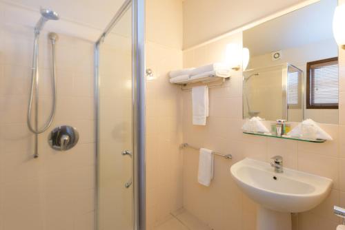 a bathroom with a shower and a sink at Oasis Beach Resort in Taupo