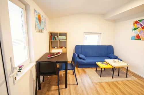 a living room with a blue couch and a table at Rezidenca Erjavec in Notranje Gorice