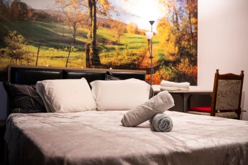 a bedroom with a bed with a painting on the wall at LL Villa Sanandrei in Sânandrei