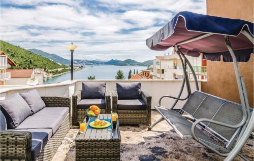 eine Terrasse mit Stühlen, Sonnenschirm und Tisch in der Unterkunft Four-Bedroom Apartment In Klek in Klek