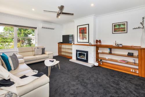 a living room with a couch and a fireplace at Lake Wendouree Luxury Apartments in Ballarat