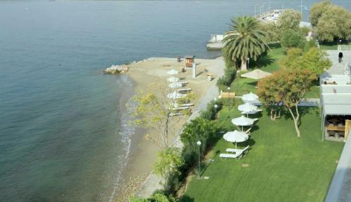 a group of umbrellas and chairs on a beach at Domotel Xenia Volos in Volos