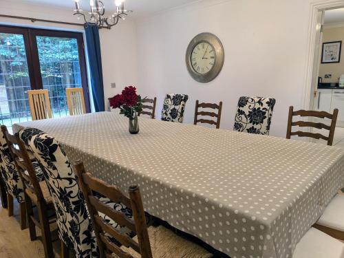 a dining room table with a vase of flowers on it at Spacious Home for Large Families and Contractors in Wolverhampton
