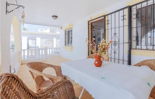 ロス・アルカサレスにあるAmazing Home In Los Alcázares With Wifiの白いテーブルと椅子、花瓶