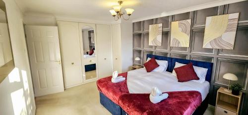 a bedroom with a large bed with a red couch at Chelmsford Comfort Retreat Spacious 4 Bedroom Sleeps 7 Free Parking in Widford