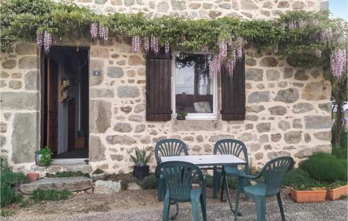 a table and chairs in front of a stone building at 2 Bedroom Awesome Home In Bas-En-Basset in Bas-en-Basset