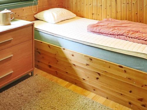 a bed in a room with a wooden floor at 4 star holiday home in OSKARSTRÖM in Oskarström