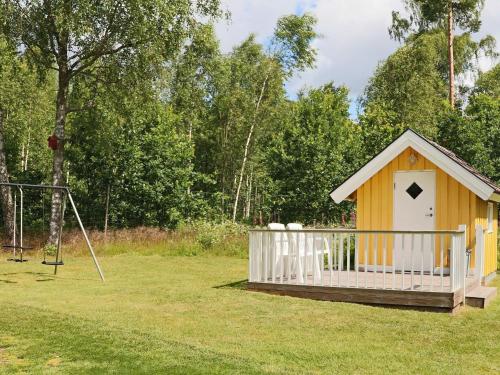 a small shack in a field with a playground at 4 star holiday home in OSKARSTRÖM in Oskarström