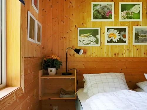 a bedroom with a bed and a lamp and pictures on the wall at 4 star holiday home in OSKARSTRÖM in Oskarström