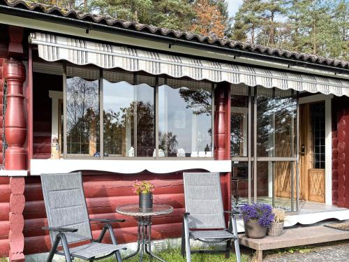 a red house with two chairs and a table on the porch at 4 star holiday home in Fengersfors in Fengersfors
