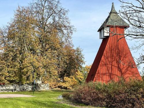 a red lighthouse with a clock tower in a field at 4 star holiday home in Fengersfors in Fengersfors