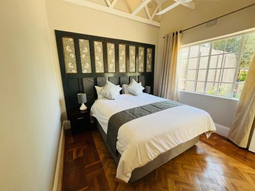 a bedroom with a large bed and a large window at The Franklyn Parkview in Johannesburg