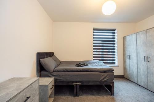 a bedroom with a bed and a cabinet and a window at 2 Ensuite Bed Home Near Shops in Denton