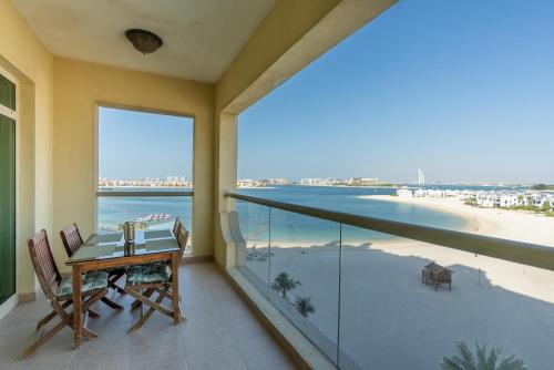 a balcony with a table and a view of the beach at Bespoke Residences - 2 Bedroom Apartment Sea View with Beach Access in Dubai