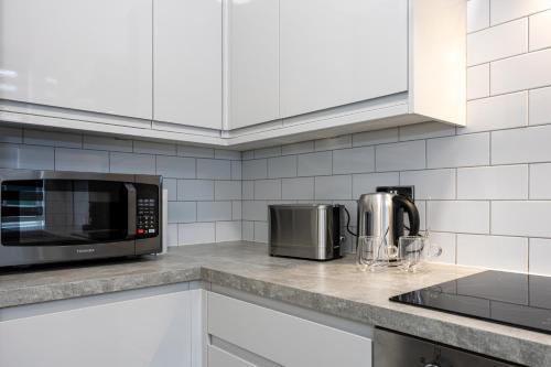 a kitchen counter with a microwave and a toaster oven at 2 Ensuite Bed Home Near Shops in Denton