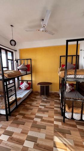 a room with several bunk beds and a table at The Hostel Stories Dharamkot - Mcleodganj in McLeod Ganj