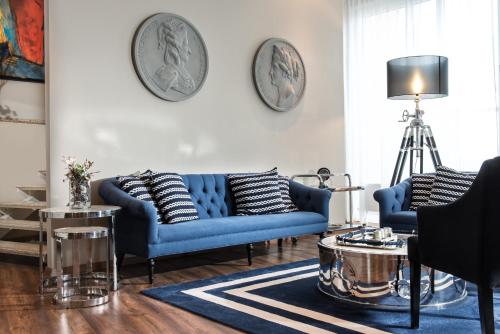 a living room with two blue couches and a table at Wyndham Garden Wismar in Wismar