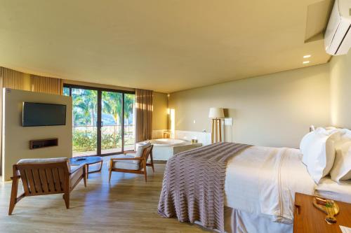 a hotel room with a bed and a bathroom at Pousada Terramare in Guapé