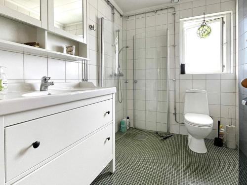 a white bathroom with a toilet and a sink at 6 person holiday home in VALDERMARSVIK in Stora Getterö