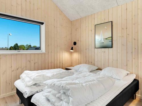 a bedroom with a large bed with a window at 5 star holiday home in Dronningmølle in Dronningmølle