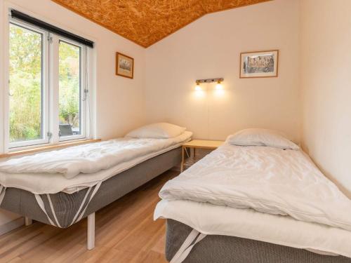 two beds in a room with a window at 6 person holiday home in Borup in Borup