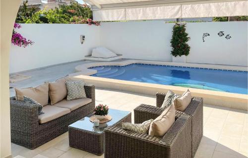 une terrasse avec des chaises en osier et une piscine dans l'établissement Amazing Home In El Chaparral With Wifi, à La Mata
