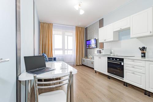 een keuken met een laptop op een witte tafel bij Central Lifestyle in Astana