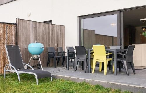 a group of chairs and tables on a patio at Nice Home In De Panne With Kitchen in De Panne