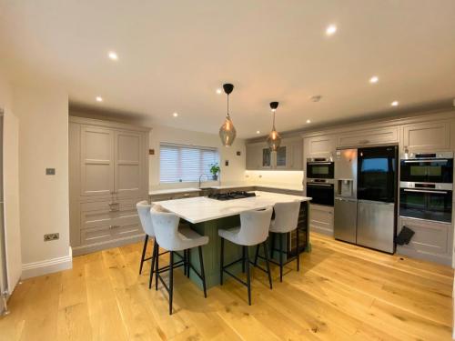 a kitchen with a large island with bar stools at House - Sleeps 9 & Private Garden in Leeds
